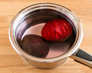 Raw beets in a bowl of water. Preparing a vegetable for cooking
