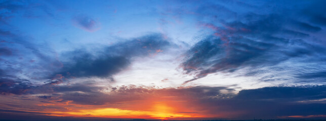 Naklejka na ściany i meble Dramatic sunset sky with clouds. Panorama.