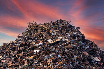 scrap metal heap at recycling junk yard against red sky at sunset - obrazy, fototapety, plakaty