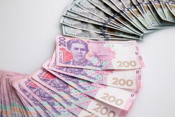 collection of hundred-dollar and two hundred hryvnia banknotes isolated on white background, close...
