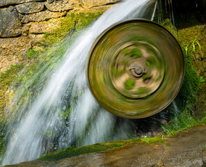 , a mill wheel spins fast from the water