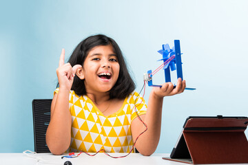 Electronic experiment - Indian girl student working with wires and connections making windmill model