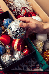 Close up image of Hands holding Colourful Christmas tree ornament decoration.