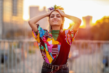 Portrait of beautiful non-binary person standing on city street at sunset
