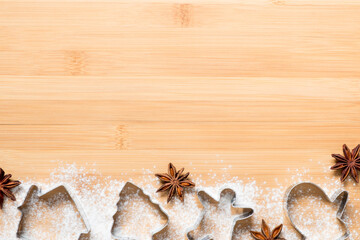 Christmas background with cookies molds, spice and flour with copy space