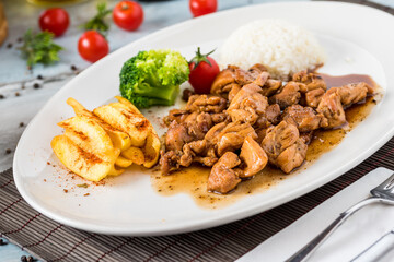 grilled chicken with rice and fried potatoes on white plate