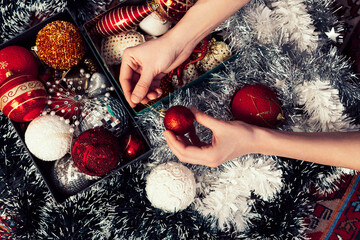 Close up image of Hands holding Colourful Christmas tree ornament decoration.