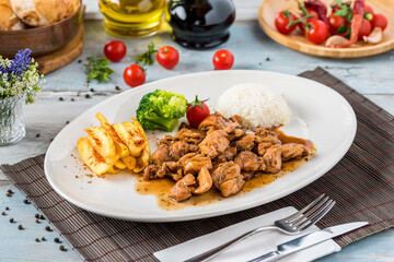 grilled chicken with rice and fried potatoes on white plate