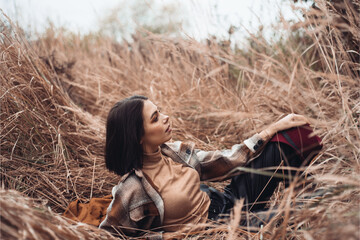 Young woman in a field with dry grass