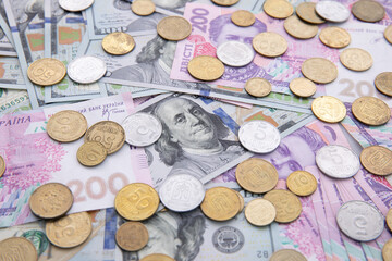 collection of hundred-dollar and two hundred hryvnia banknotes with coins isolated on white background, close view