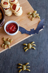 spiders from olives lie on the board, next to bats and ketchup. happy halloween