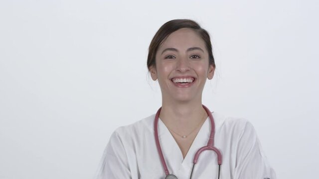 Hispanic medical personnel smiling and laughing against white backdrop.