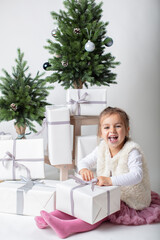 Fototapeta na wymiar Super happy toddler girl ready to open her Christmas gift