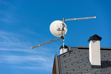 Close-up of a Television aerial (antenna) and a satellite dish on the roof of a residential...