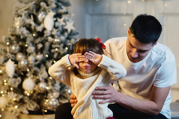 Obraz premium Cozy Xmas Morning Family At Home Near Chritmas Tree. Celebration Atmosphere. Magic Lights Christmas Tree Interior. 