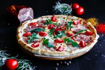 Obraz na płótnie Canvas Thin pizza with ham and tomatoes