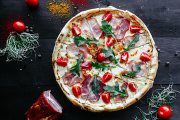 Thin pizza with ham and tomatoes