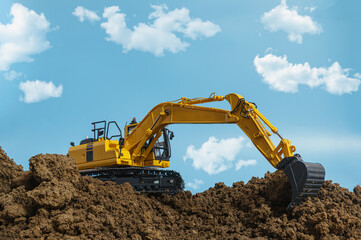 Yellow excavators are digging the soil in the construction site on the cloud and  sky  background