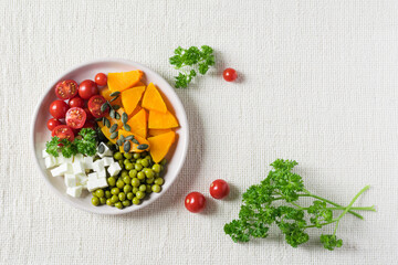 Salad with pumpkin, parsley, tomatoes and feta cheese, healthy food for diet. Top view, copyspace