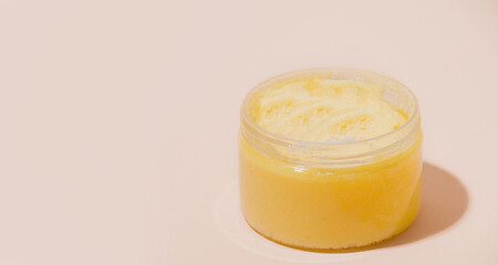 Yellow face and body scrub on a beige background. Copy space