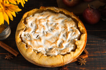Pear pie, fruits, spices and a bouquet of flowers on a wooden dark table. Copy space.
