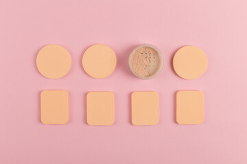 A lot of sponge, a beautiful blender for applying foundation or powder. Flat lay on a pink background, copy space.