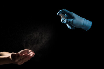 Person in gloves spraying antibacterial disinfectant on hands to avoid virus isolated on black background