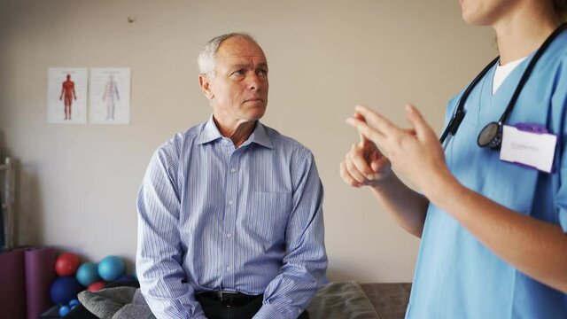 Female nurse advising elderly man on healthy lifestyle.