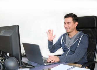 Man in casual outfit working from home with a laptop in the living room