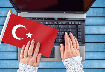 woman hands and flag of Turkey on computer, laptop keyboard
