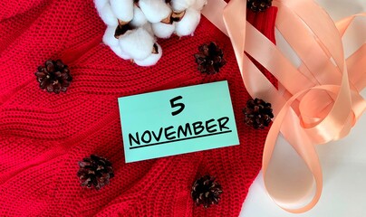 November 5.November 5 on a blue piece of paper.Cones, cotton and ribbon.Autumn .Calendar for November.
