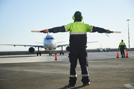The runway traffic controller uses gestures and sticks to help the aircraft choose the correct trajectory around the airfield