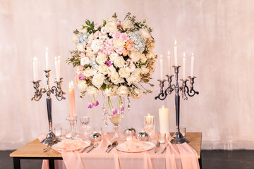 Decorating a wedding table with candles and expensive dishes. Close-up