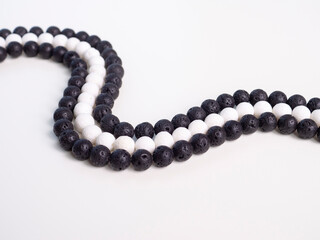 Black and white beads from natural semi-precious stones on a white background