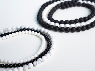 Beads from black lava stone and white coral on a white background