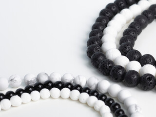 Obraz premium Black and white beads from natural semi-precious stones on a white background