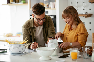 Husband and wife in kitchen. Young couple preparing delicious food at home.