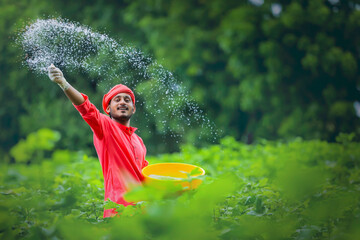 Indian farmer spreading fertilizer in the green banana field