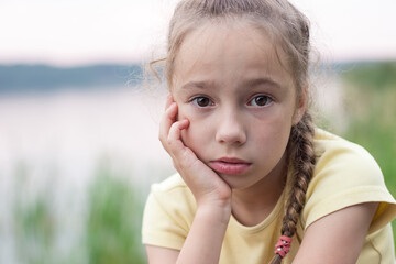 Sad little girl is crying and  looking with serious face at camera