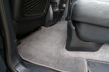 Clean carpet on the floor of passenger seats in a car made of gray fabric after washing and dry cleaning, requirements for the interior in a taxi.