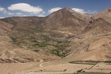 Fototapeta na wymiar A village on the slopes of a high barren mountain in the Spiti valley