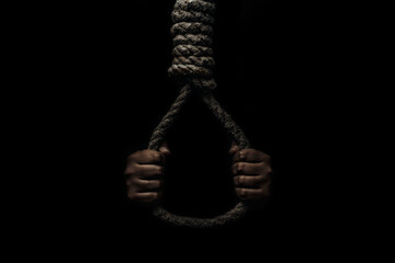 Hand holds a noose on a black background. Social problem. The end of the path - obrazy, fototapety, plakaty