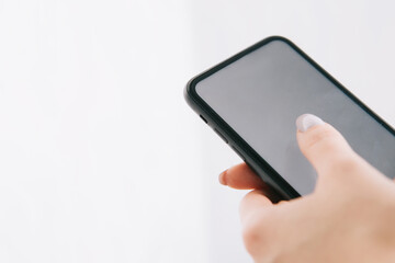 phone with a white screen in the hands of a girl with a manicure, copy space