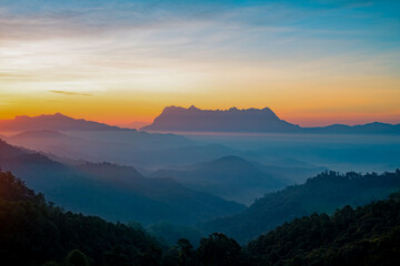 Scenery of the sky gradient from blue to orange sunrise over the valley at Doi Luang, Chiang Dao, Chiang Mai, Thailand.