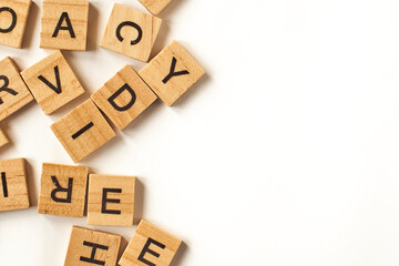 Top view of square wooden tiles with the English alphabet scattered on a white background with space for text. The concept of thinking development, grammar.