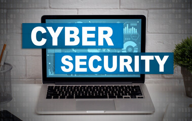 Laptop on office table with abstract digital symbols or hologram and inscription cybersecurity on screen