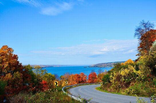 Landscape with road, autumn foliage, mountains and Cayuga Lake, one of Finger Lakes in New York 