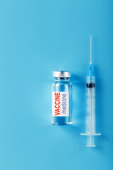 Medicines with syringe Vaccine ampoule on a blue background.