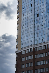 Fototapeta premium new multi-storey building of burgundy white color against the sky in the windows of which the sun is reflected