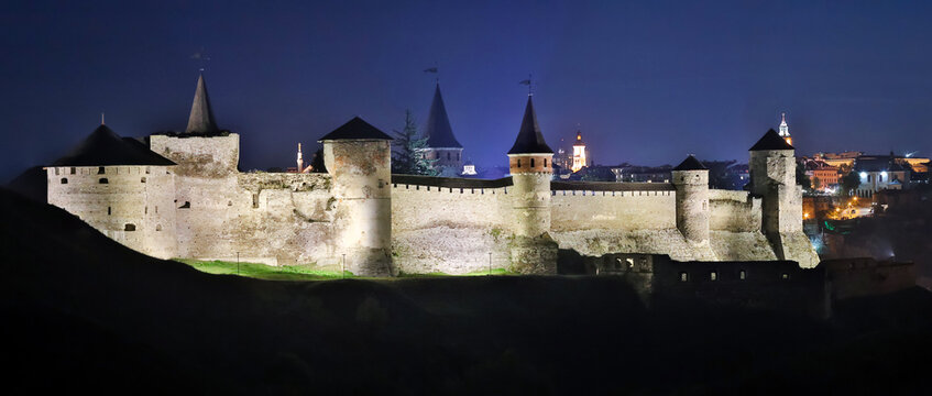 Panoramic  night view of ancient fortress castle in Kamianets-Podilskyi, Khmelnytskyi Region, Ukraine. Old Castle photo on a postcard or cover. Long exposive